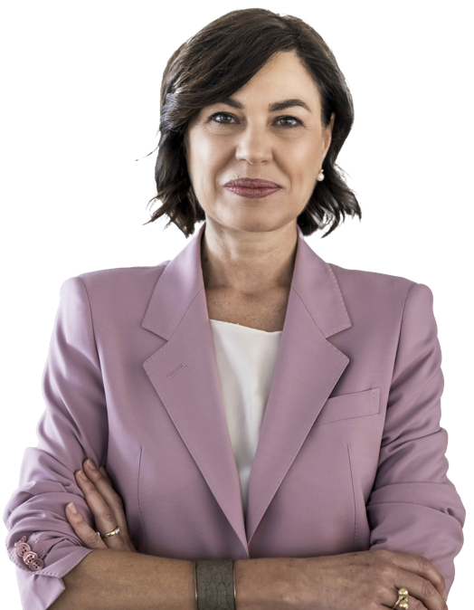 Frau mit dunklem Haar in einem rosa Blazer vor weißem Hintergrund.