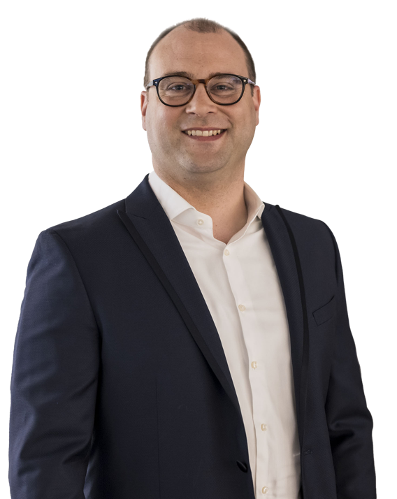 Eine lächelnde Person in einem Anzug und Hemd vor weißem Hintergrund.